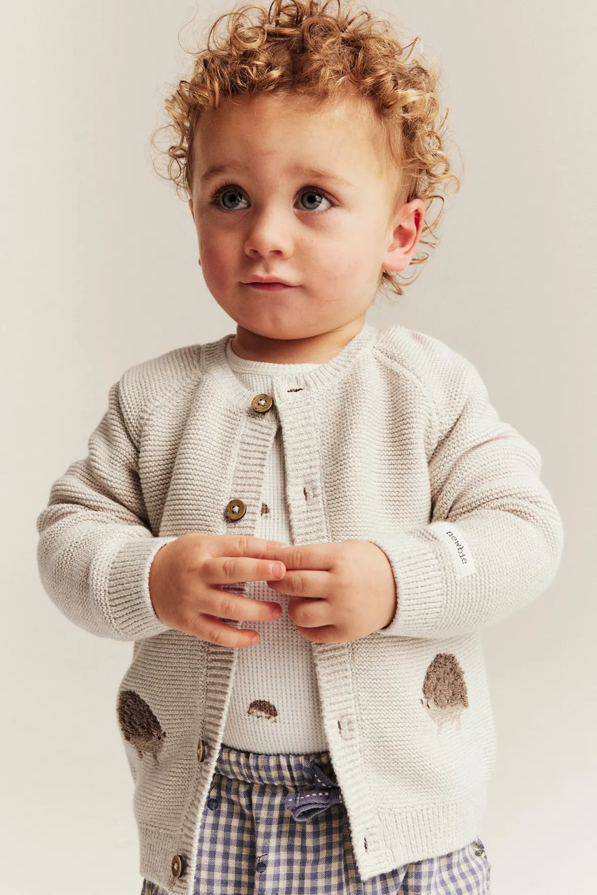Baby beige knitted cardigan with hedgehog motif